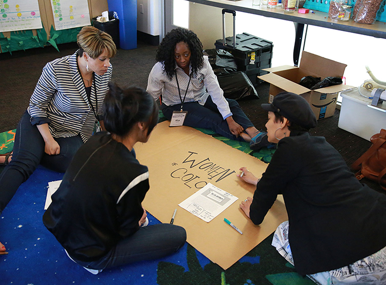 Four educators work on a project titled "women of color"