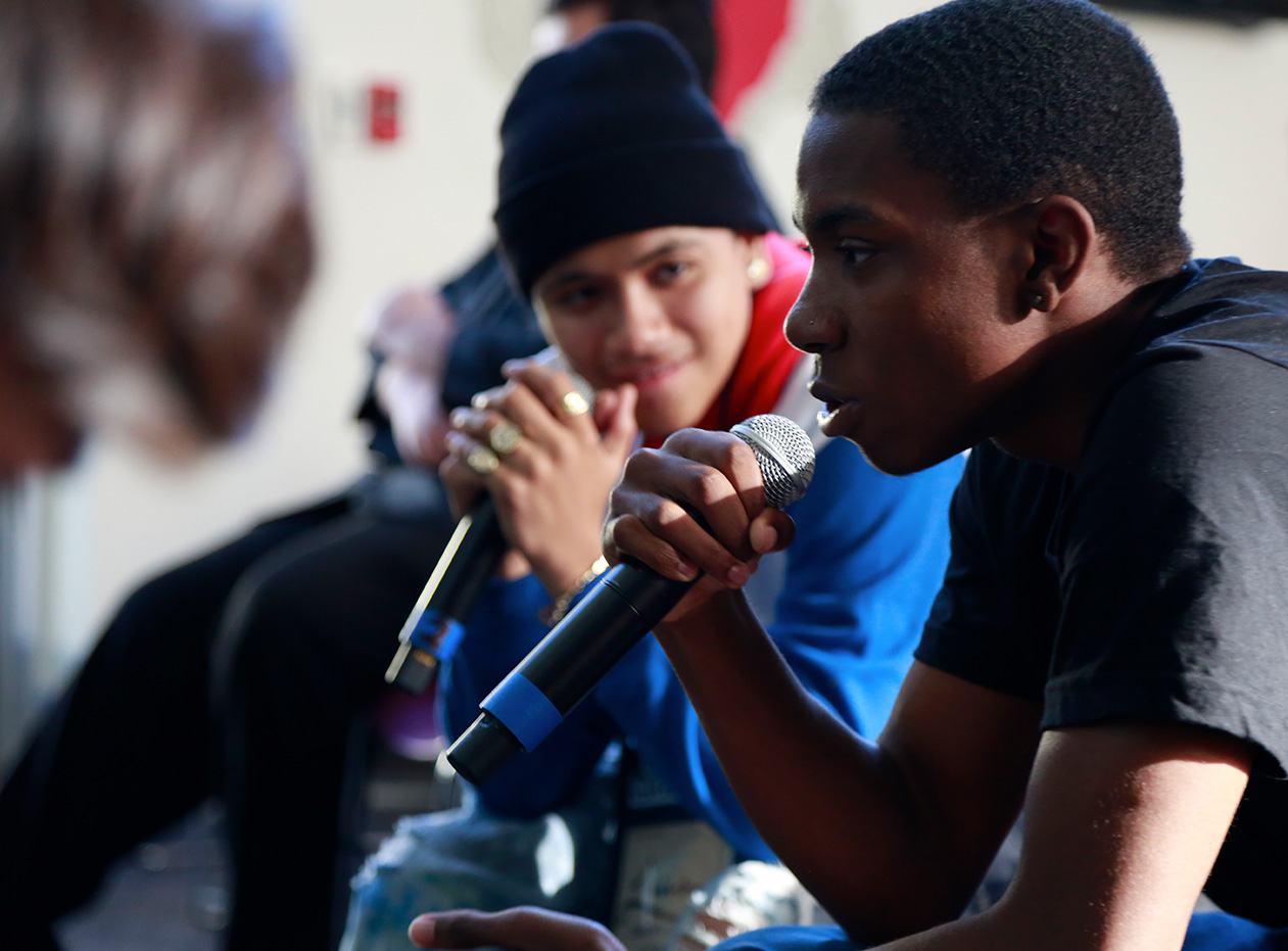 Two students speak into microphones